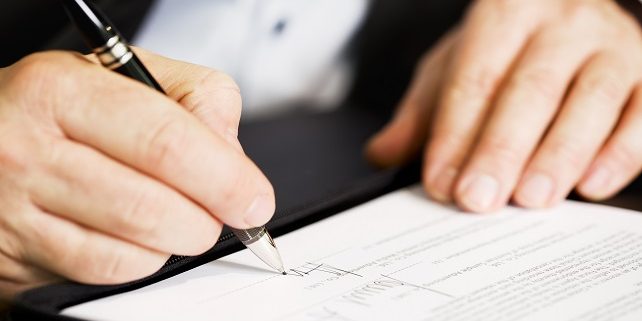 Close up of businessman signing a contract.